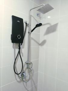 a shower with a shower head in a bathroom at Happy Chamang Guest House in Bentong