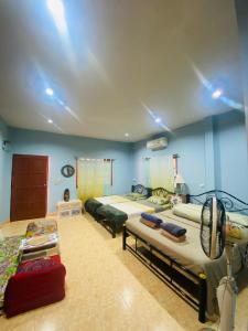 a bedroom with two beds and a fan in it at Ganesha bungalow at Ya Nui beach in Phuket Town