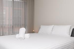 a bedroom with a white bed with towels on it at Contemporary Tri-Level APT in a Prime Central Spot in Canberra