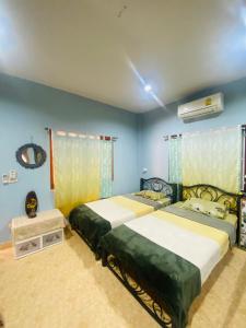 two beds in a room with blue walls at Ganesha bungalow at Ya Nui beach in Phuket Town