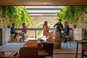 Un groupe de personnes assises autour d'un baril dans un restaurant dans l'établissement Jacobs Estate Cottage, à Rowland Flat