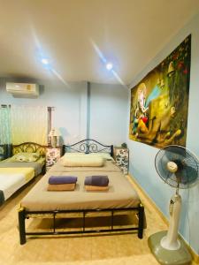 a bedroom with two beds and a painting on the wall at Ganesha bungalow at Ya Nui beach in Phuket Town