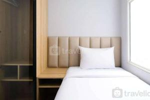 a bed with a white pillow in a room at Apartement At Klaska Residence in Surabaya