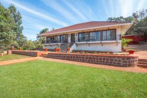 a house with a lawn in front of it at StayVista's Villa Terra - Valley & Lake-View Villa with Spacious Lawn & Indoor Activities in Panchgani