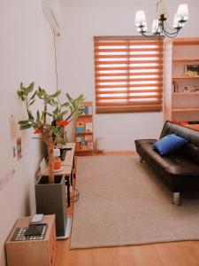 uma sala de estar com um sofá de couro e uma mesa em Denmaru em Sokcho