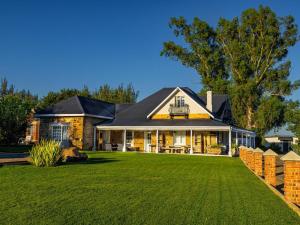 una casa grande con césped delante en Retief Guest Farm, en Kroonstad