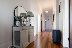 a hallway with a dresser with a mirror on it at Ohio House in Launceston