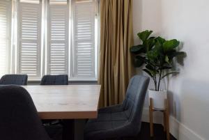 a dining room table with chairs and a potted plant at Ohio House in Launceston