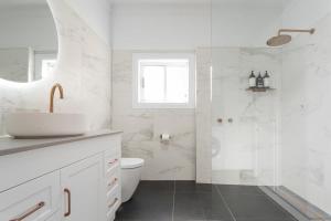 a white bathroom with a sink and a shower at Historic Beauty in the CBD with Parking & WiFi in Launceston +25 photos