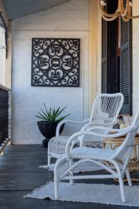 twee witte stoelen op de veranda van een huis bij Historic Beauty in the CBD with Parking & WiFi in Launceston
