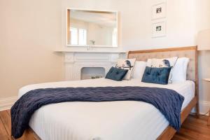 een slaapkamer met een groot bed met blauwe kussens bij Historic Beauty in the CBD with Parking & WiFi in Launceston