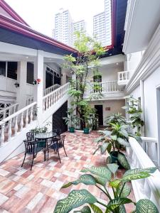 SANTOS Pension House في مانيلا: شرفة مع طاولة وكراسي والنباتات