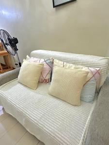 a white couch with three pillows on it at Condo in Newport City Pasay near NAIA T3 AIRPORT MANILA in Manila