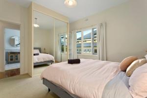 a bedroom with a large bed and a mirror at Magnolia House: Near the Cataract Gorge & Parking in Royal Park