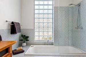 a bath tub in a bathroom with a window at Magnolia House: Near the Cataract Gorge & Parking in Royal Park +13 photos