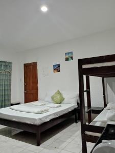 een slaapkamer met een bed en een stapelbed bij Moalboal Beach Front Hotel in Moalboal