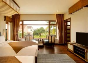een slaapkamer met een bed en een groot raam bij Hoi An Ocean Front Hotel in Hội An