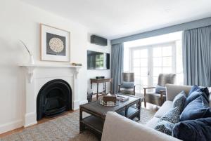 sala de estar con sofá y chimenea en Lovingly Restored Hampton's Haven, en Kings Park