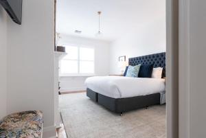 1 dormitorio con cama y ventana en Lovingly Restored Hampton's Haven, en Kings Park