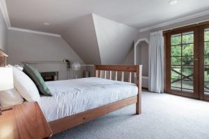 1 dormitorio con 1 cama con sábanas blancas y ventana en Gracelands Swiss Inspired Home with Gorgeous Grounds, en Hadspen