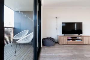 een woonkamer met een televisie en 2 stoelen bij Modern & Convenient in Newstead in Newstead