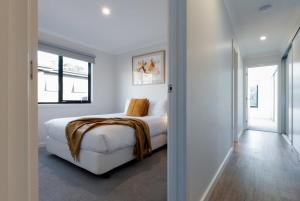 een witte slaapkamer met een bed en een raam bij Modern & Convenient in Newstead in Newstead