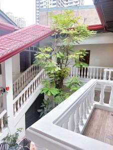 a balcony of a house with a tree on it at SANTOS Pension House in Manila
