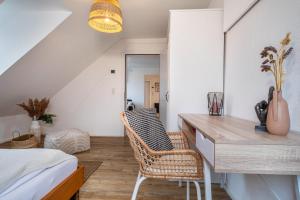 1 dormitorio con 1 cama, escritorio y sillas en Seezauber Bregenz en Bregenz