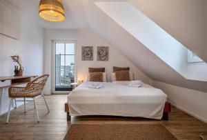 1 dormitorio blanco con 1 cama y 1 silla en Seezauber Bregenz en Bregenz