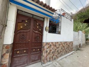 una porta marrone sul lato di una casa di Casa genesis a Panajachel