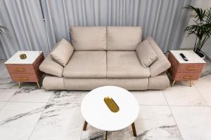 ein Wohnzimmer mit einem Sofa und einem Tisch in der Unterkunft Maison 31 -Luxury Apartments in Santa Marinella