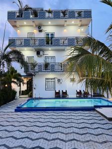 a villa with a swimming pool in front of a building at Blue Diamond Resort in Trincomalee