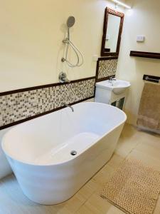 a white bath tub in a bathroom with a sink at Latui Loft in Savusavu