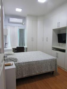 a bedroom with two beds and a kitchen and a television at Studio La Amazon in Belém