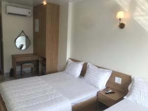 カットバ島にあるSea Balcony Hotelのベッドルーム(白いベッド2台、鏡付)