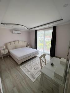 a white bedroom with a bed and a table and a table sidx sidx at blue depth villa in Fethiye