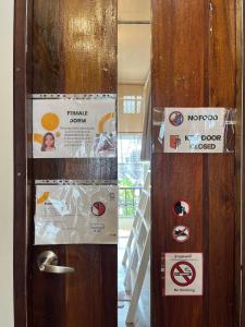 a door with signs on it in a room at Lay low hostel in Ubon Ratchathani
