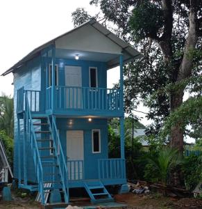 una casa azul con una escalera que conduce a ella en Tanjong Tinggi Cottage en Sijuk