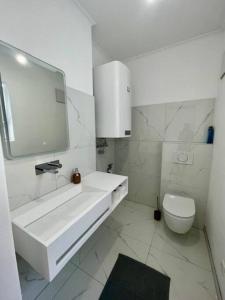 Baño blanco con lavabo y aseo en *Luxus in der Grazer Innenstadt*, en Graz