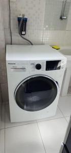 uma máquina de lavar roupa branca sentada no chão de uma casa de banho em Studio La Amazon em Belém