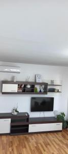 a living room with a television and a white wall at Hellen Apartament in Târgovişte