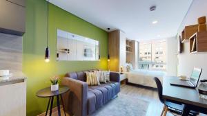 uma sala de estar com um sofá e um quarto em Exclusivos Aptos amoblados en el edificio Cabrera 85-12 em Bogotá