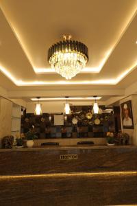 Vits Select Kharadi Pune في بيون: الثريا معلقه فوق مكتب استقبال في فندق