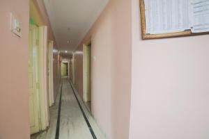 a hallway with white walls and a picture on the wall at SPOT ON Shraddha Hotel in Nagpur