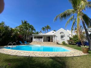 una casa con piscina y una palmera en Villa Baleine Bleue piscine&vue, en Saint-Paul