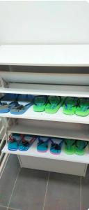 a shelf filled with lots of green flip flops at Camelia Youth City Nilai Studio residence 5pax in Nilai
