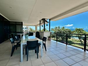 a dining room with a table and chairs on a balcony at Lighthouse Apartments on The Strand - Penthouse in Townsville