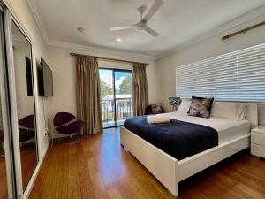 a bedroom with a bed and a large window at Lighthouse Apartments on The Strand - Penthouse in Townsville