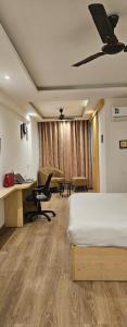 a hotel room with a bed and a desk at The Grand hotel and suites studio M Leo in Jaipur