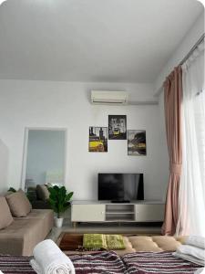a living room with a couch and a tv at Camelia Youth City Nilai Studio residence 5pax in Nilai